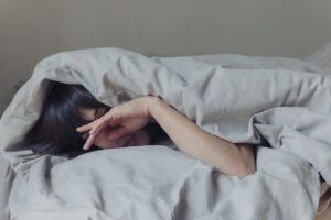 Chica descansando en cama con duvet.